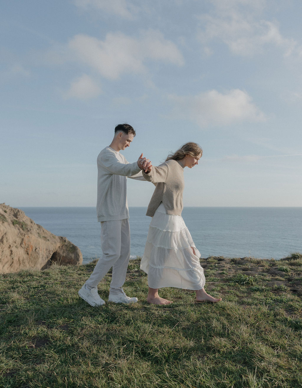 A couple taking engagement photos on a mountain in Point Reyes national park