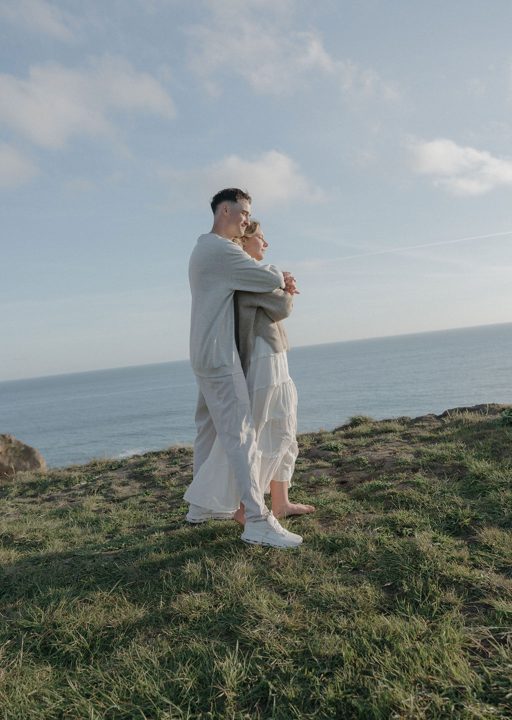 A couple taking engagement photos on a mountain in Point Reyes national park