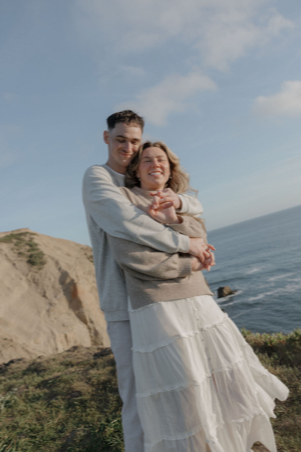 A couple taking engagement photos on a mountain in Point Reyes national park