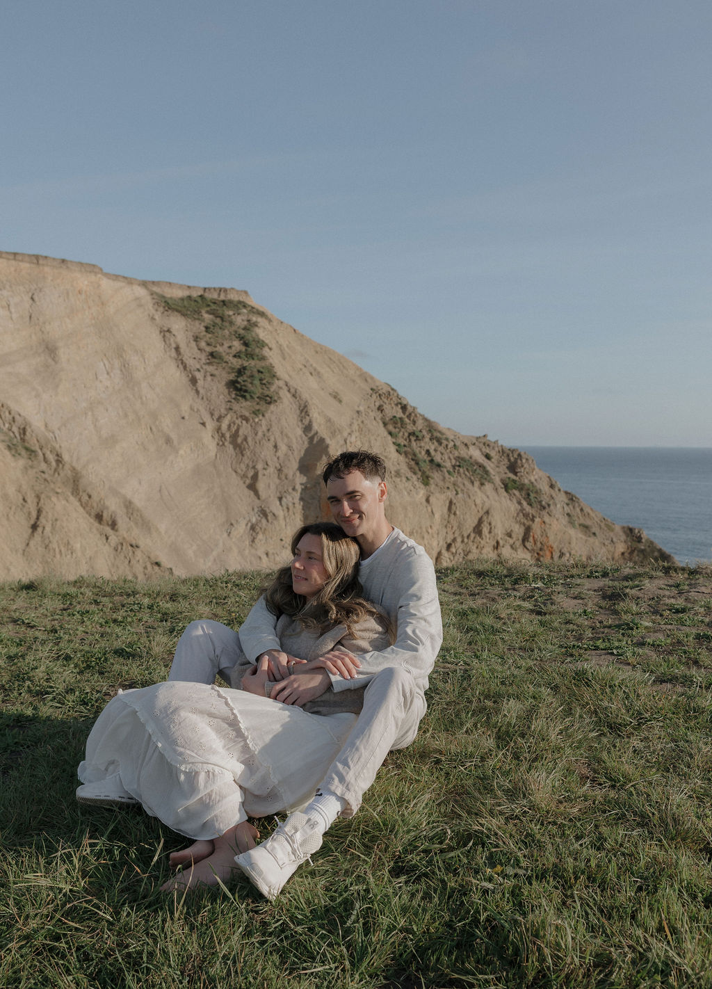 A couple sitting on the ground for Point Reyes engagement photos