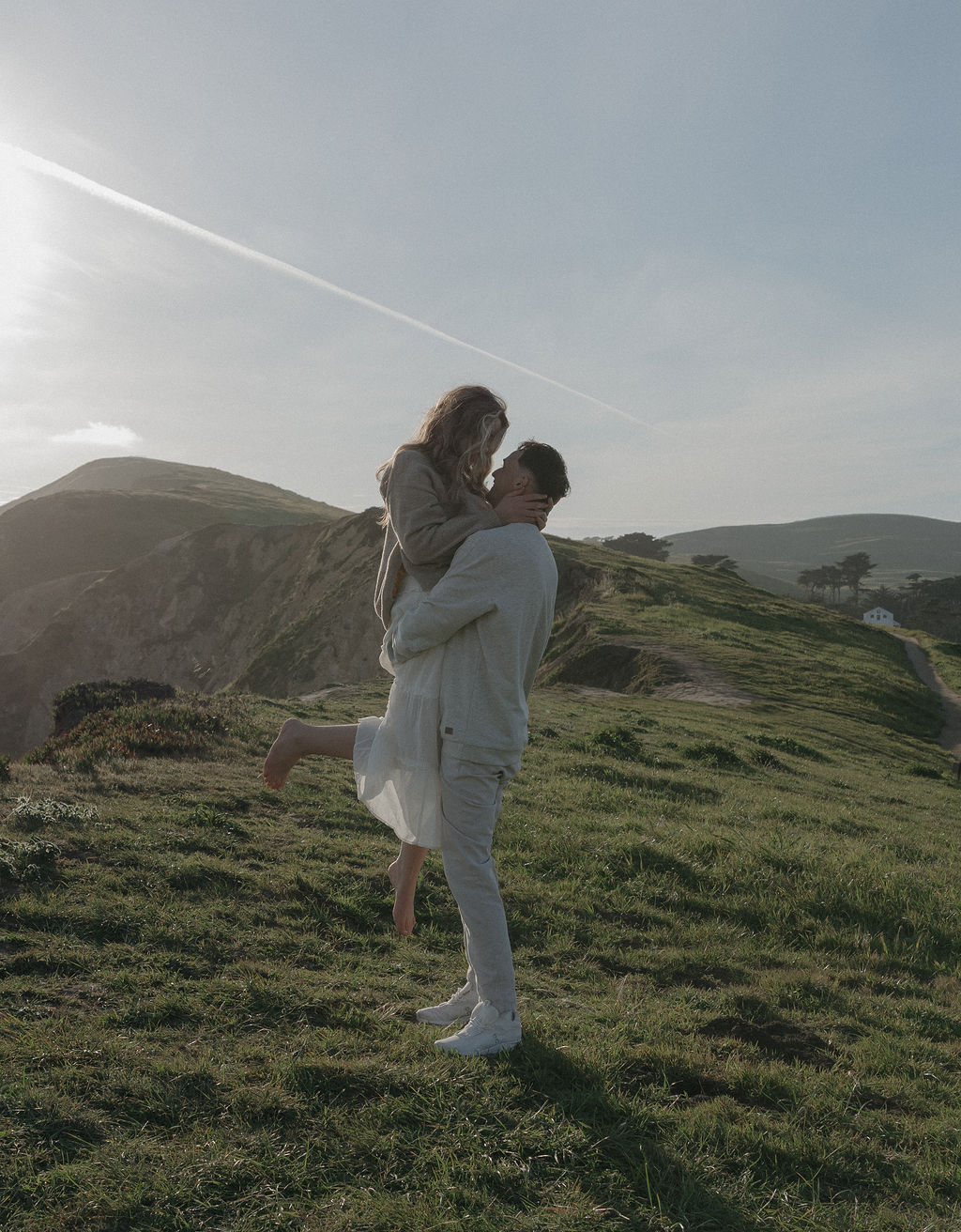A man holding his fiancee during engagement photos at Point Reyes