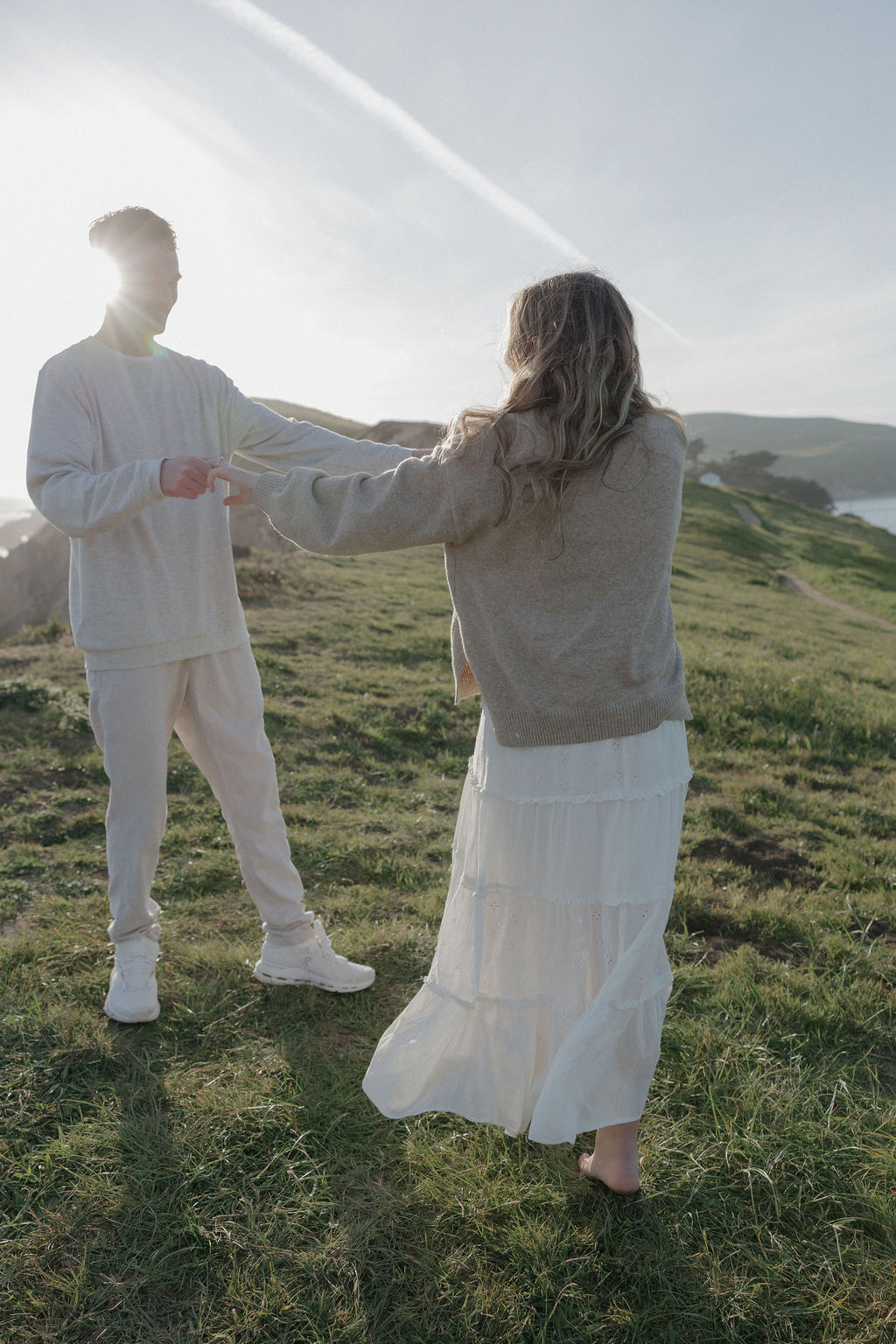 A couple holding hands while dancing during their engagement photoshoot