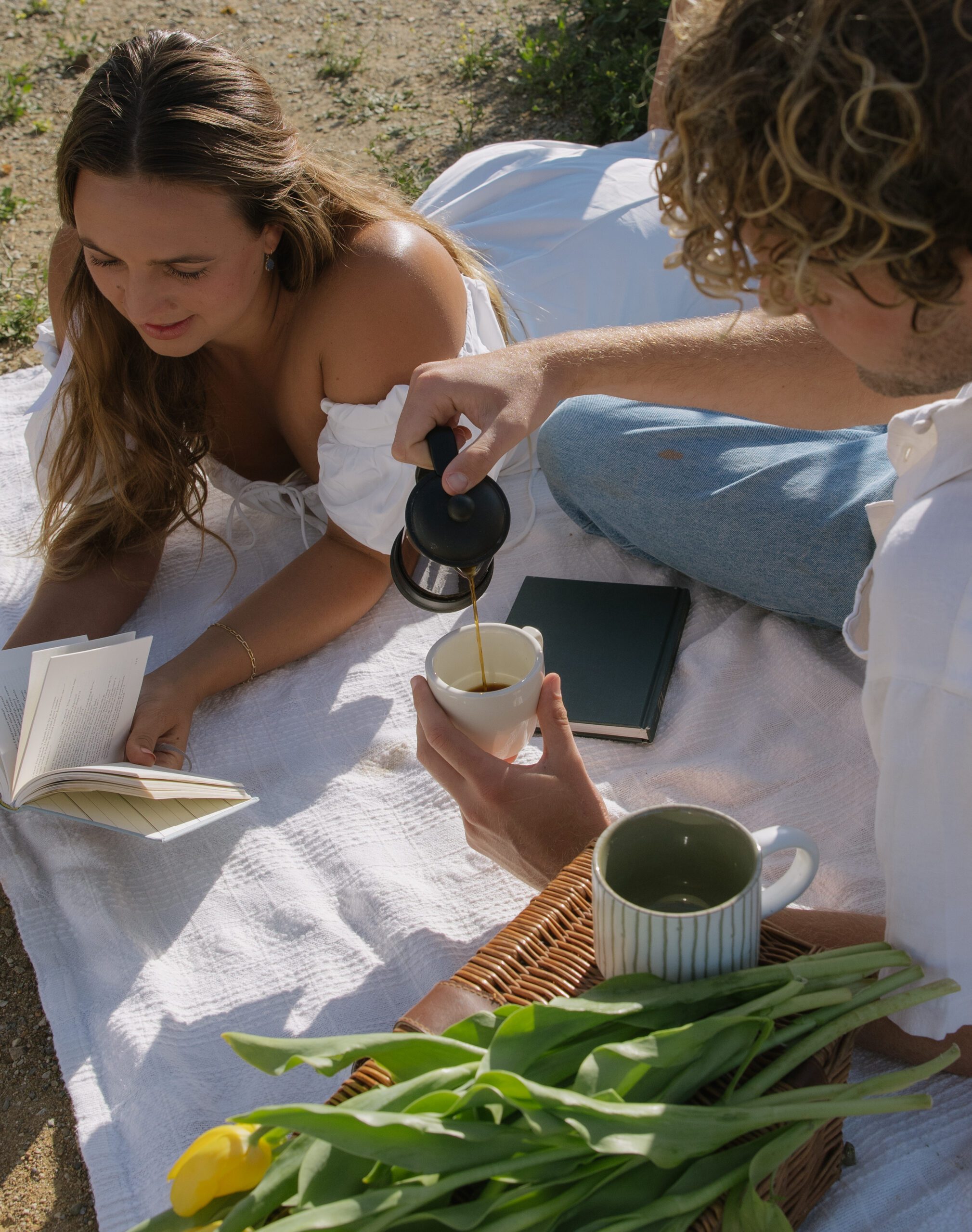 A couple having a picnic for their Malibu Beach engagement photoshoot