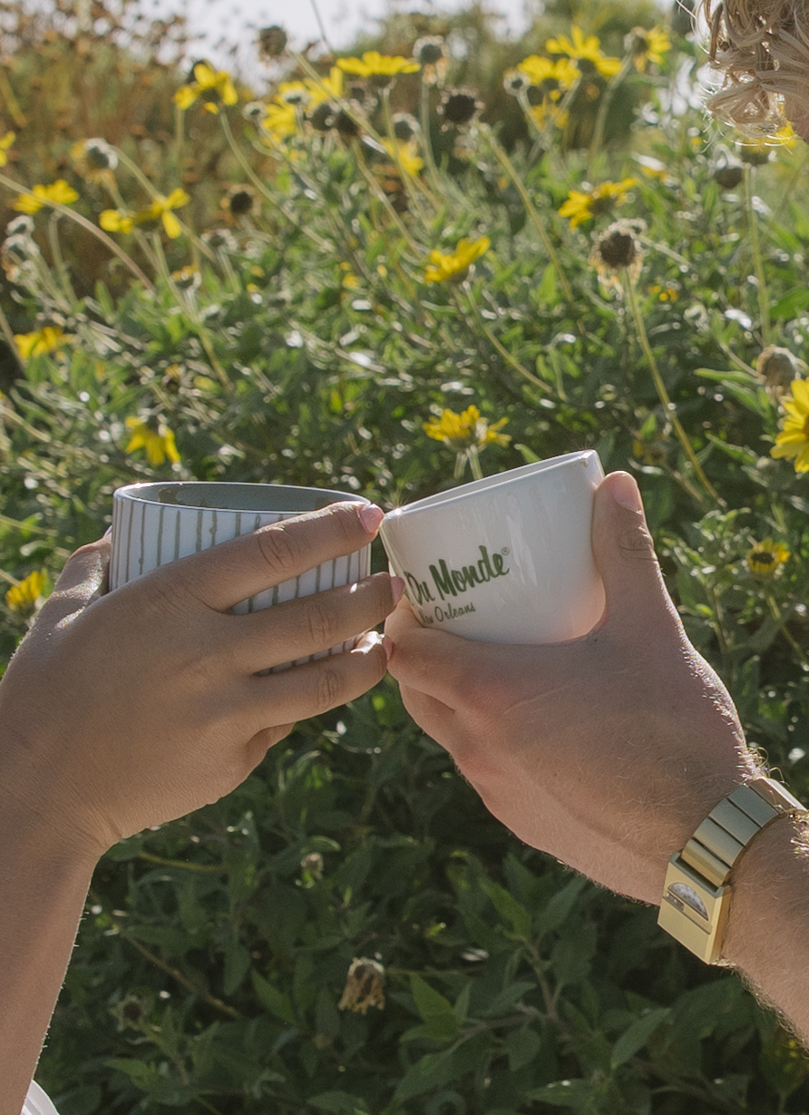 A couple clinking their coffee mugs during Malibu Beach photos