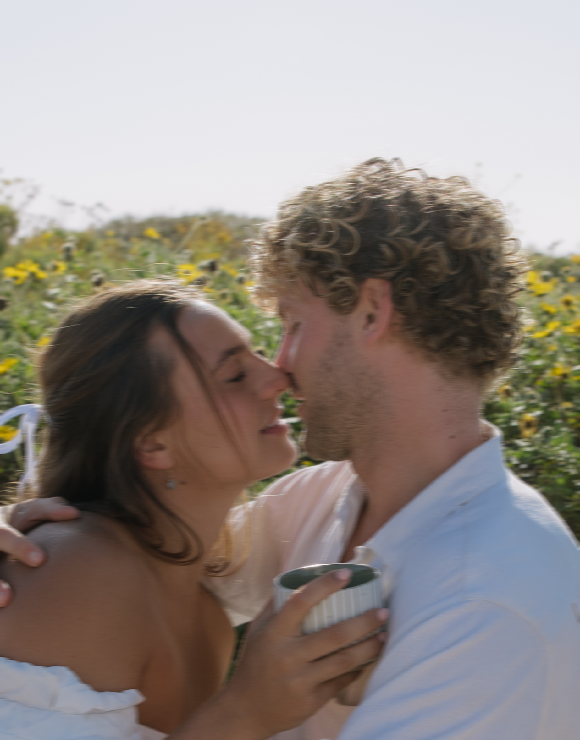 A couple leaning in for a kiss during their picnic beach engagement pictures