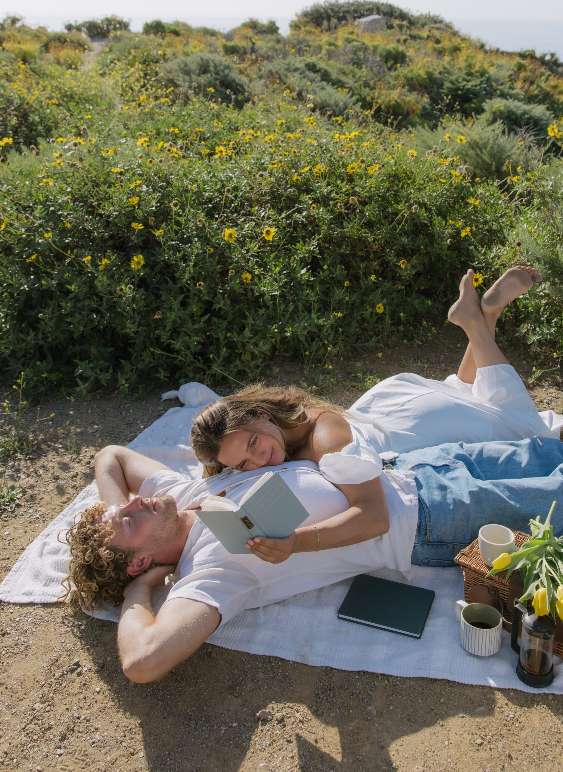 A couple having a picnic for their Malibu Beach engagement photoshoot