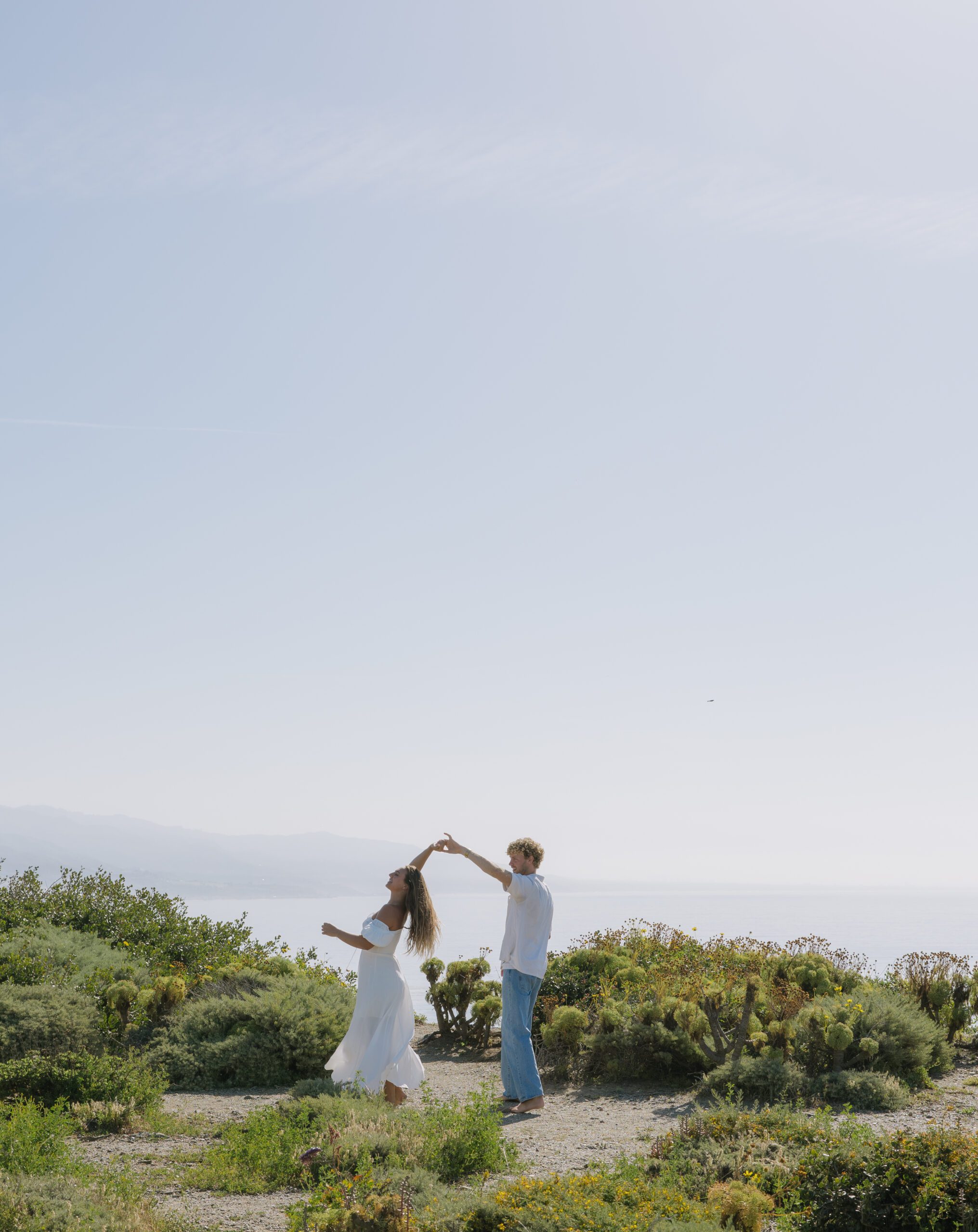 A couple dancing during their beach engagement pictures