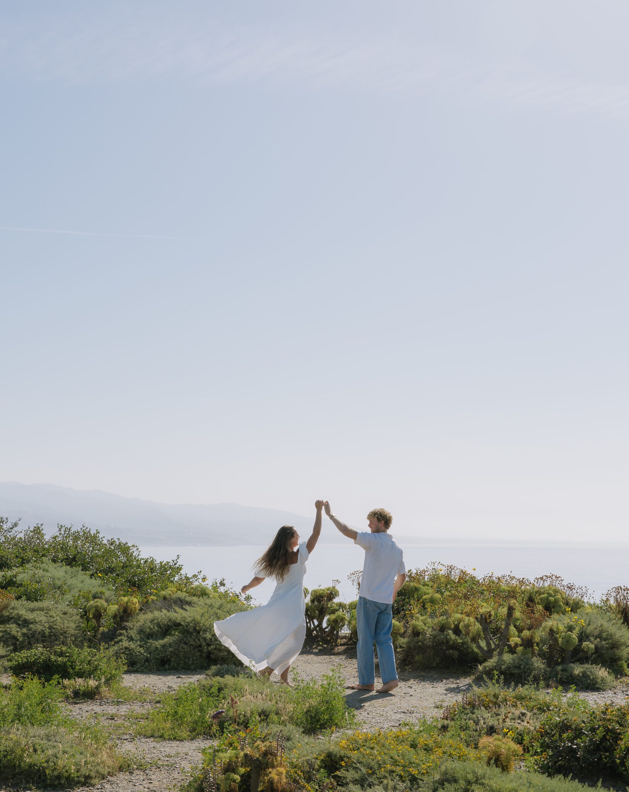 A couple dancing during their beach engagement pictures