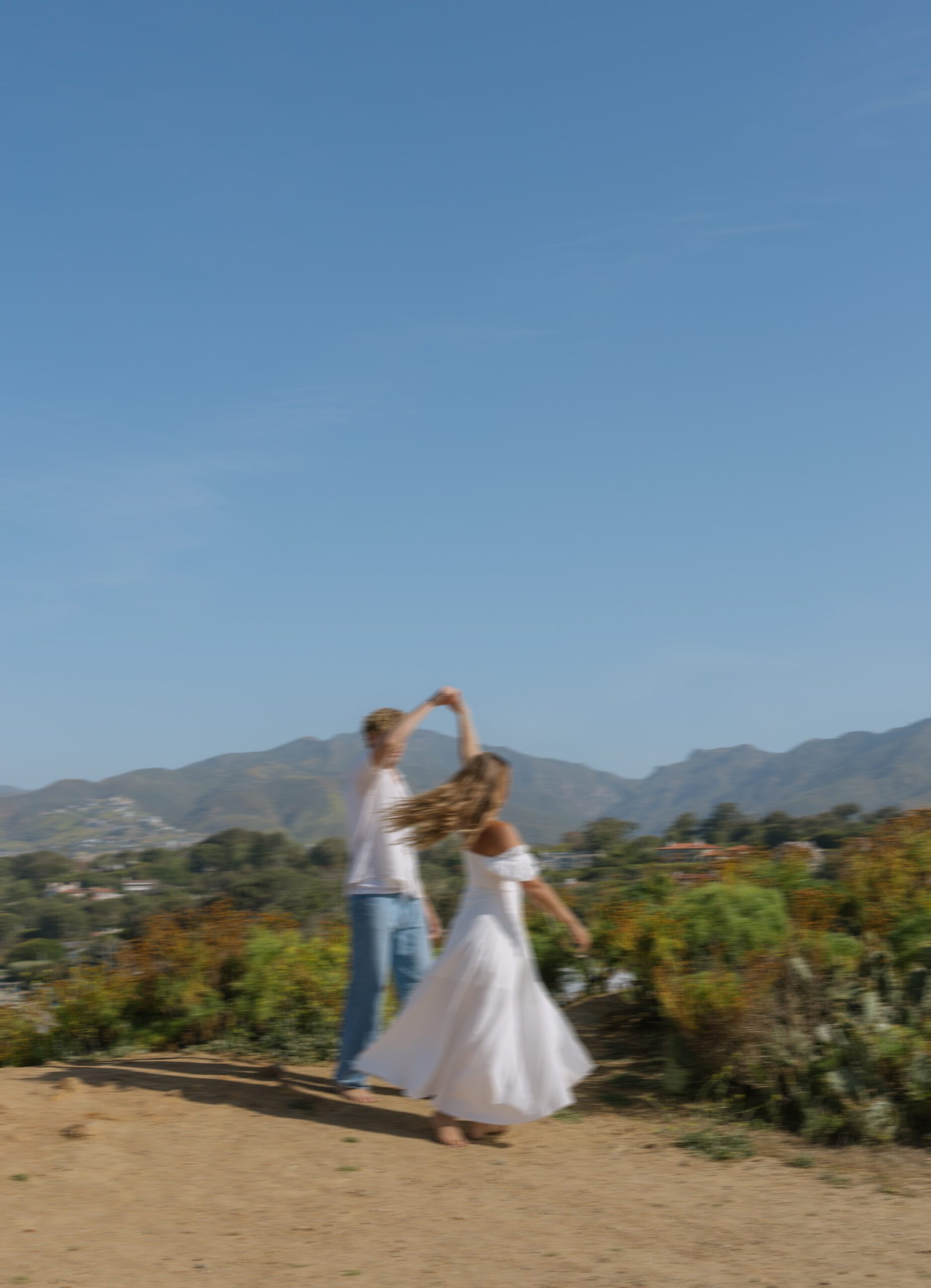 A couple dancing during their beach engagement pictures