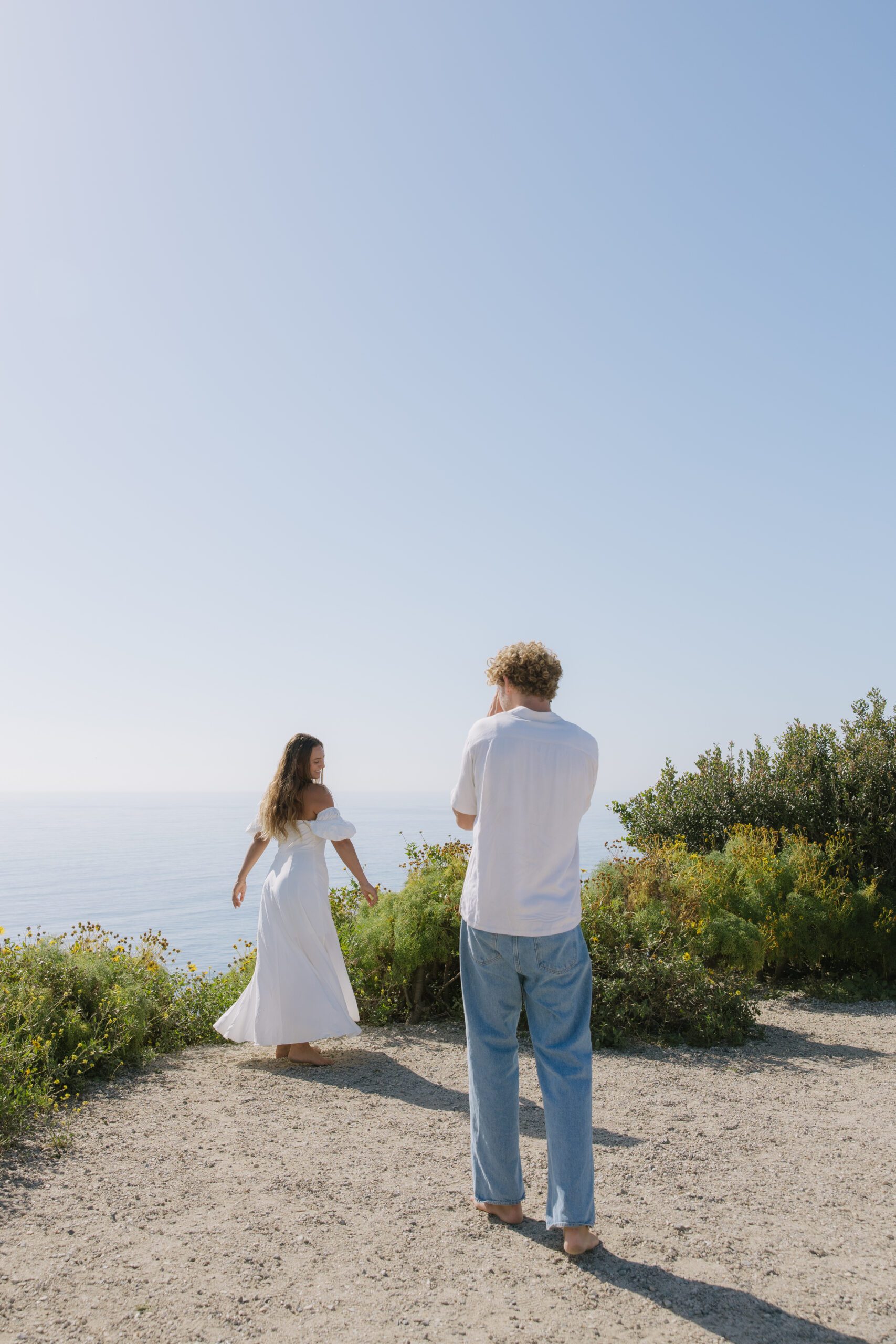 A man taking pictures of his fiance during their Malibu Beach photos