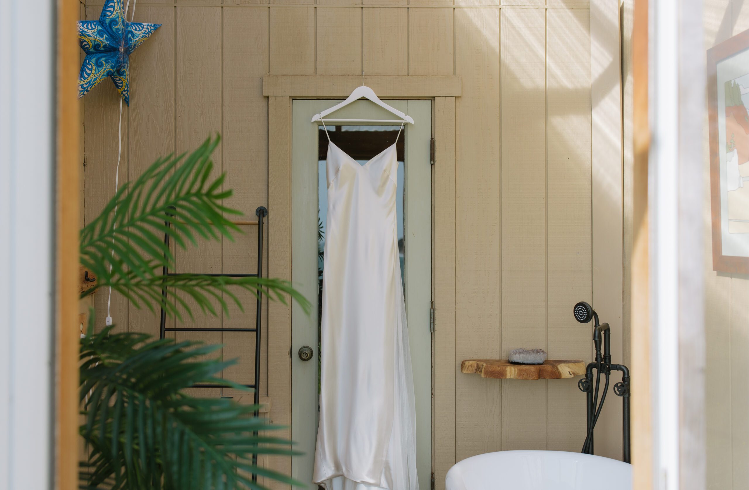 A satin wedding dress hanging up outside