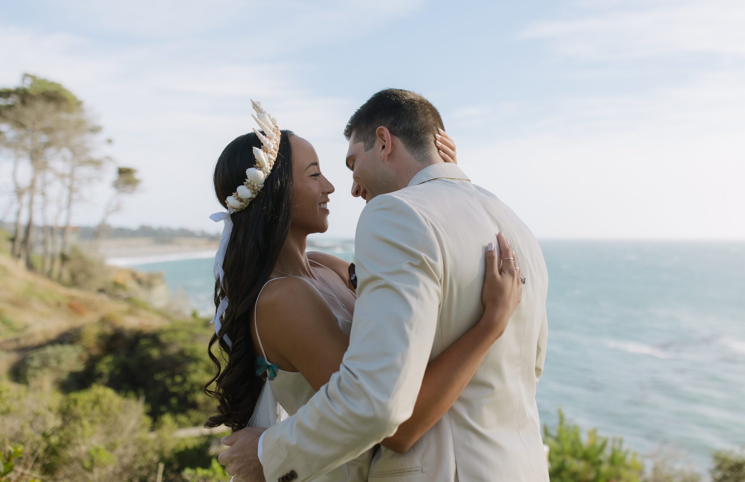 A bride and groom posing for photos at their waterfront wedding location in Bodega Bay
