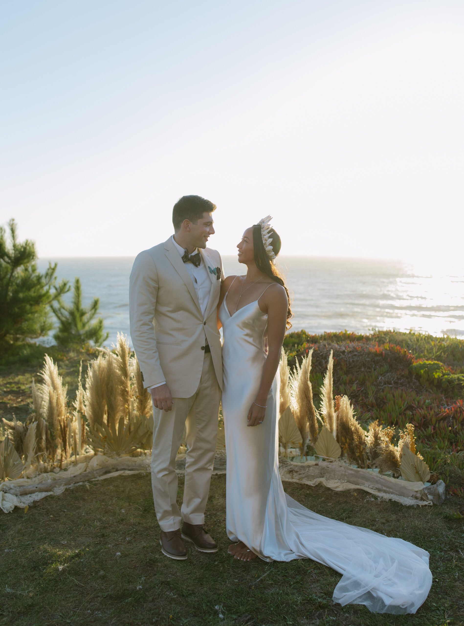 A bride and groom posing for photos at their waterfront wedding location in Bodega Bay