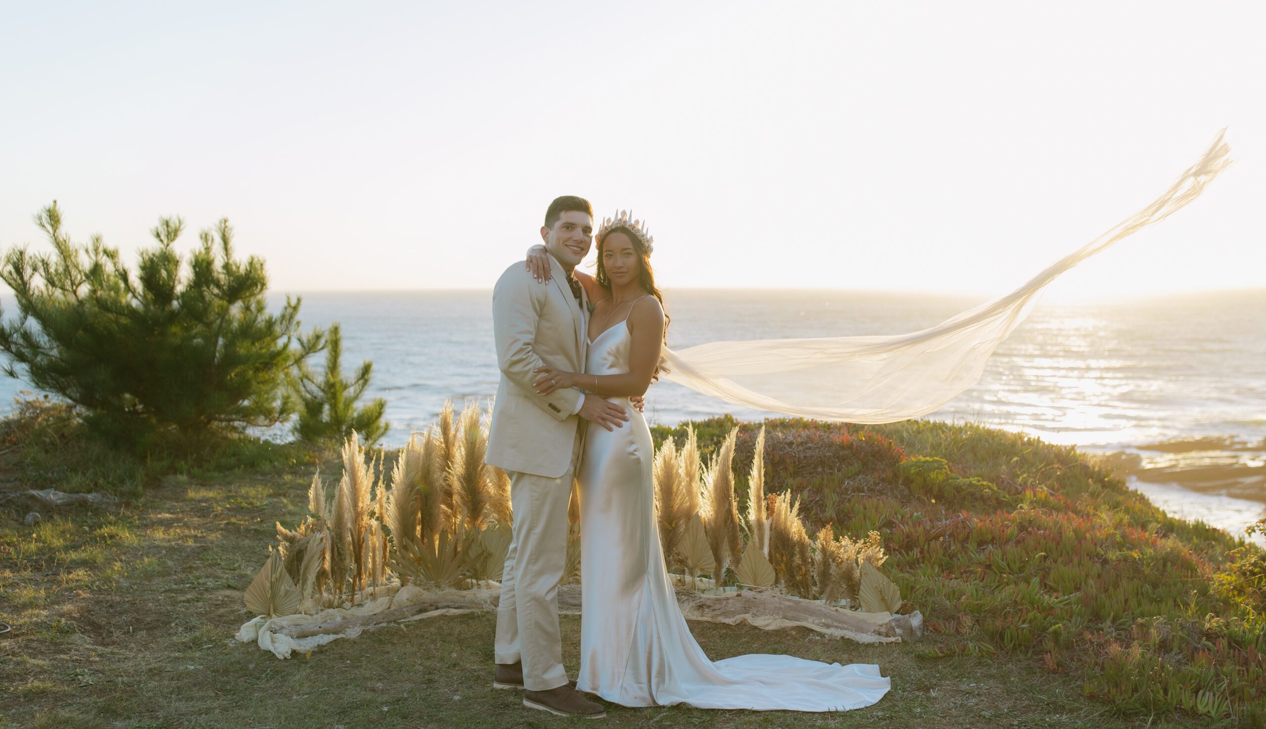 A bride and groom posing for photos at their waterfront wedding location in Bodega Bay