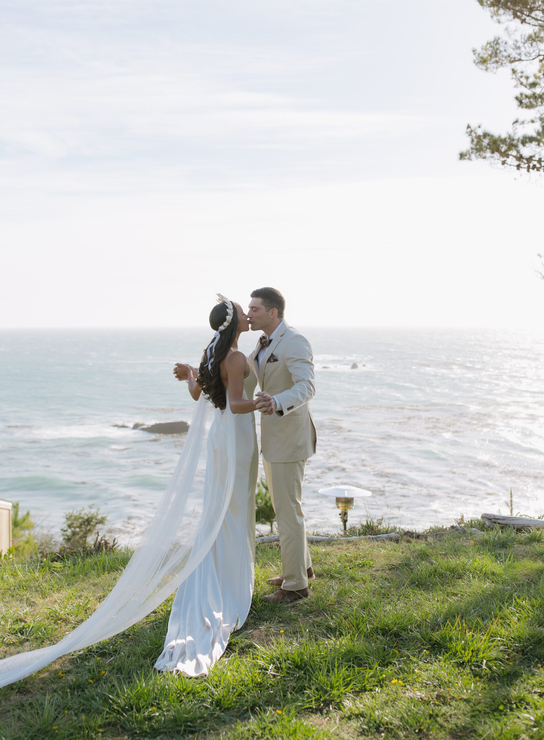 A bride and groom posing for photos at their waterfront wedding location in Bodega Bay