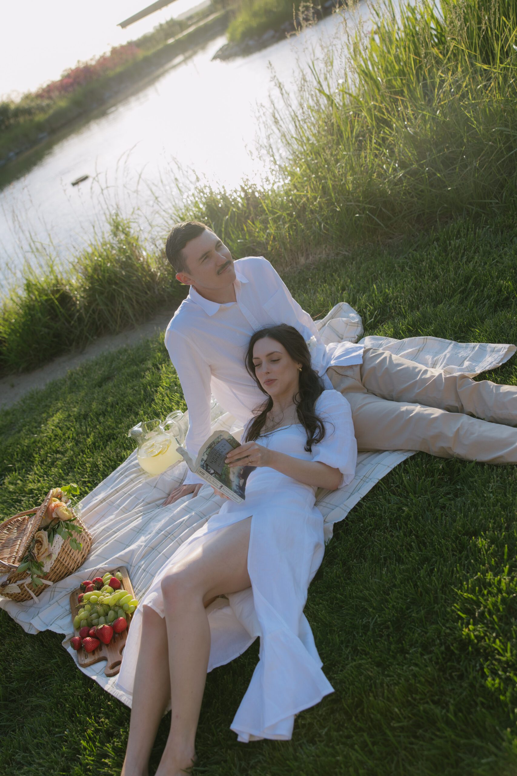 A woman reading at a picnic for her engagement photoshoot