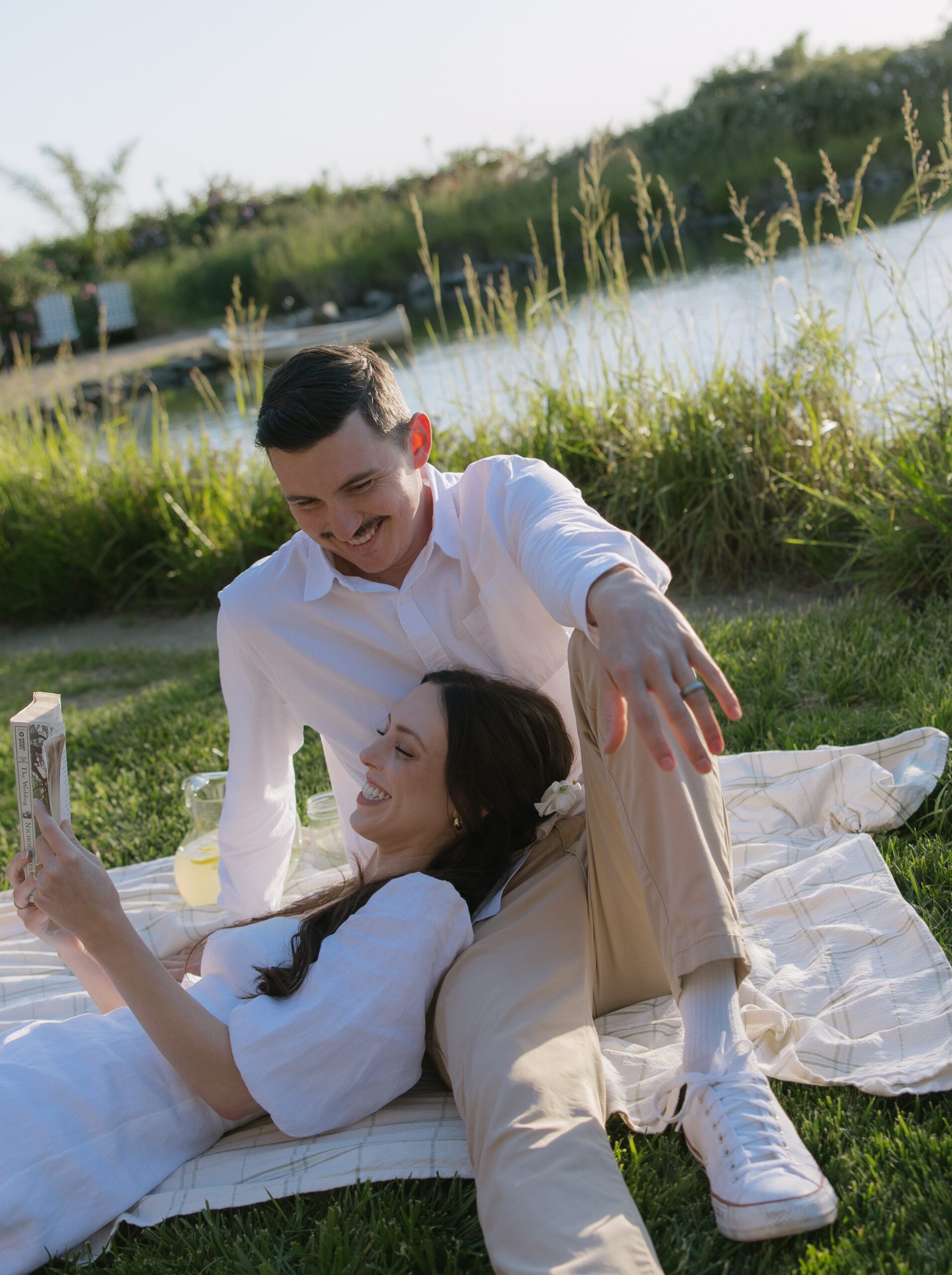 A woman reading on her fiances lap for engagement photos