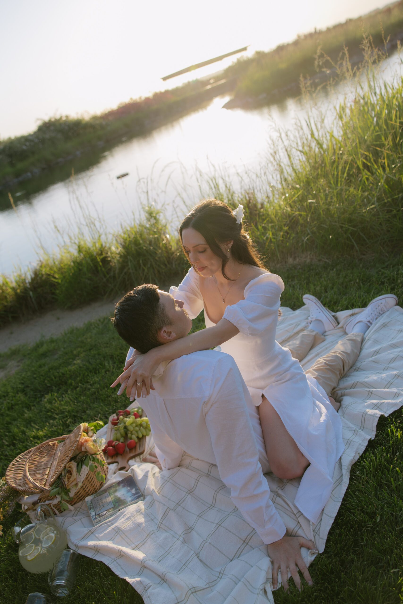 A couple posing for engagement photos at a picnic