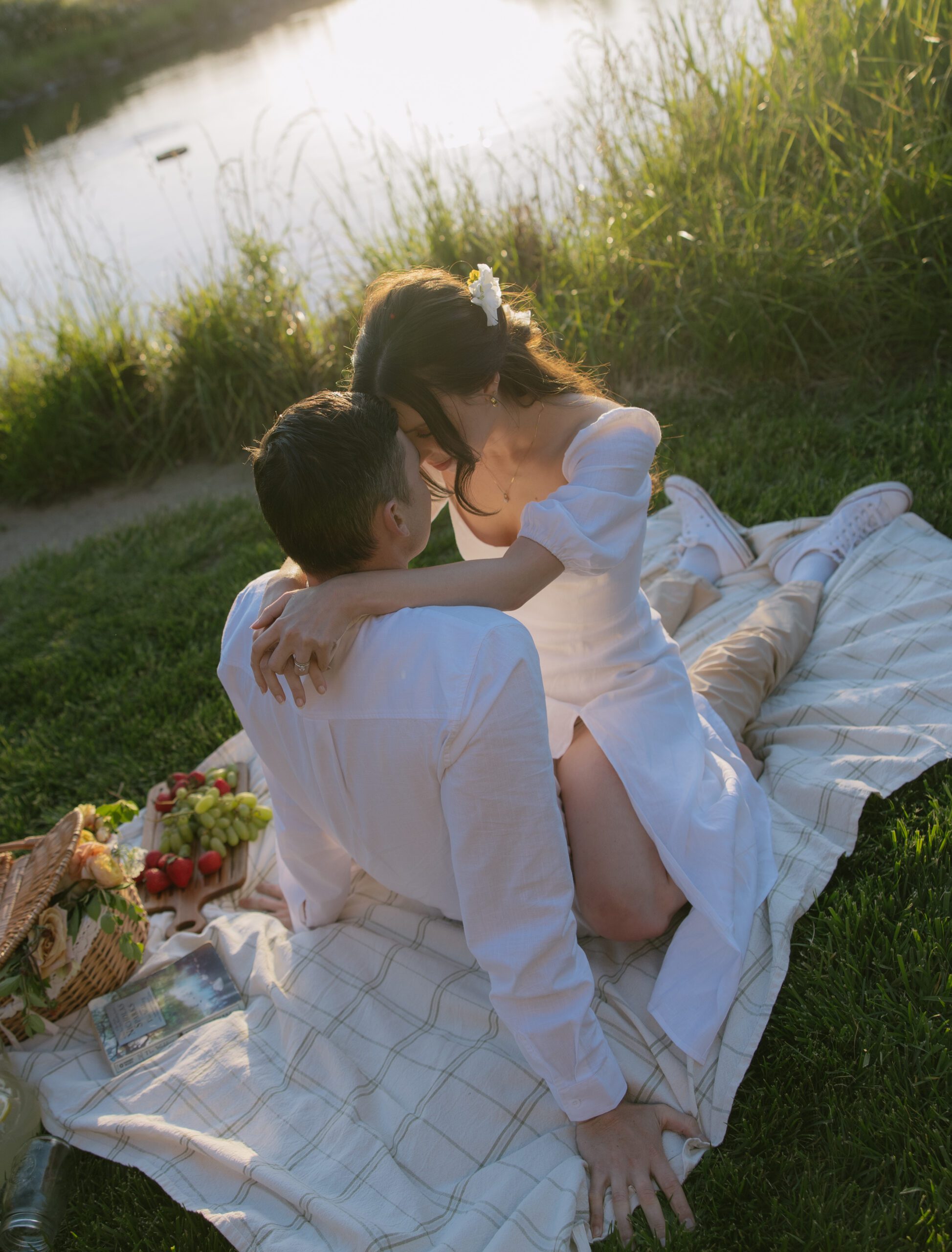 A couple posing for engagement photos at a picnic