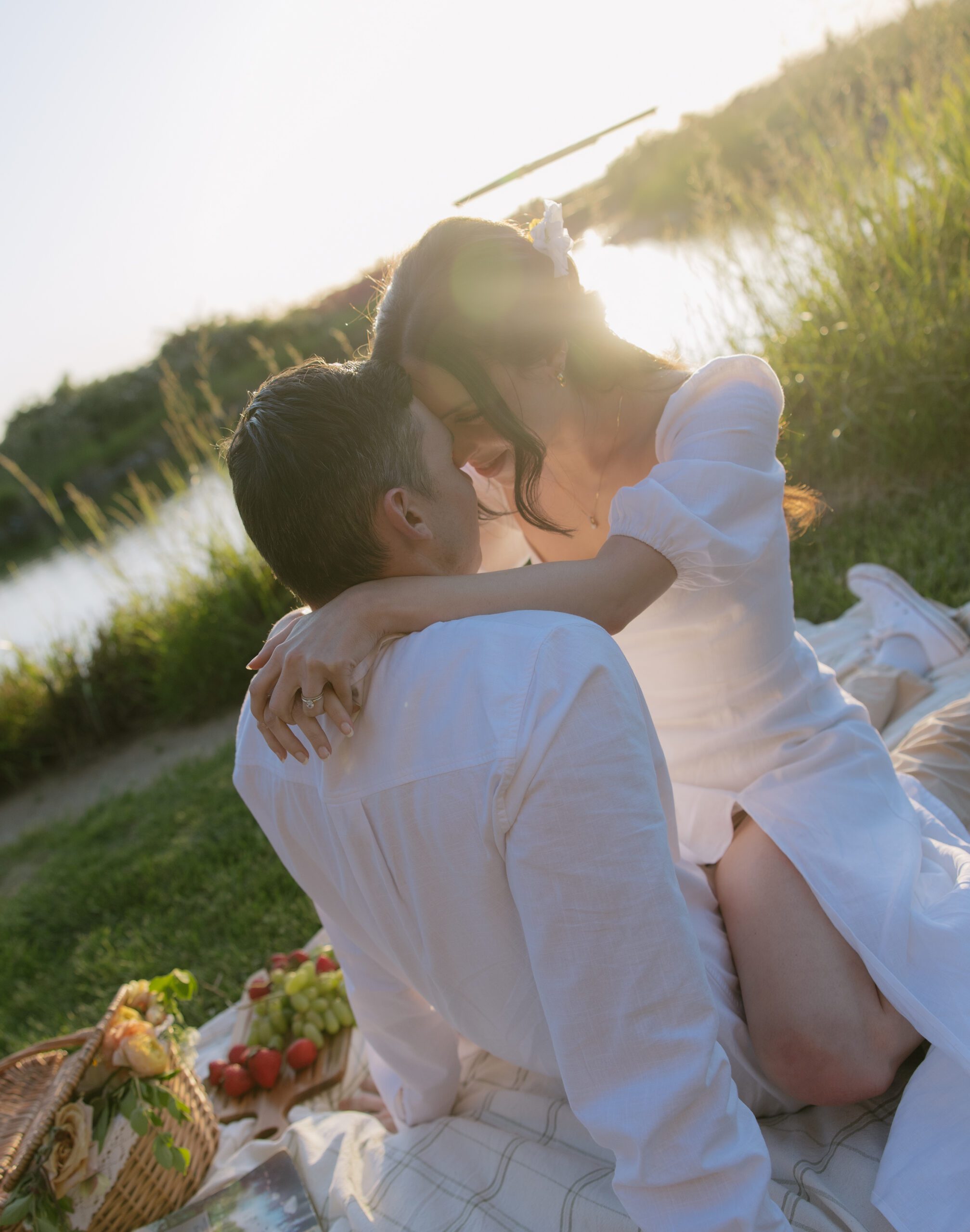 A couple posing for engagement photos at a picnic