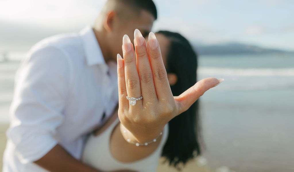 A bride showing off her ring to the camera for engagement photos