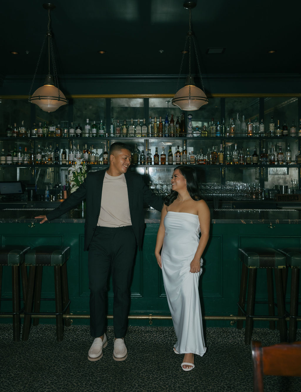 A couple posing in a bar for engagement photos