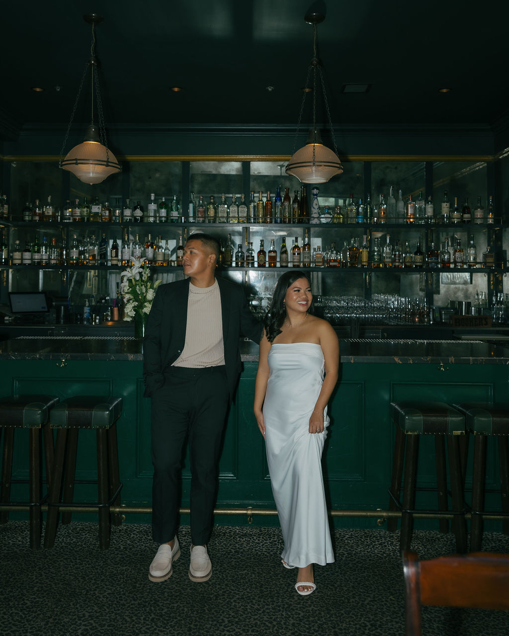 A couple posing in a bar for engagement photos