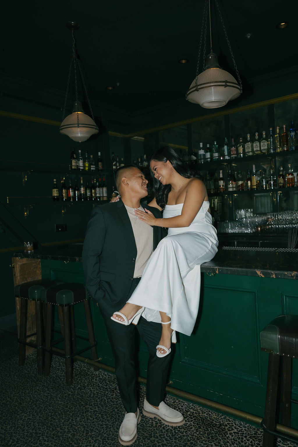 A woman sitting on a bar during bar engagement photos