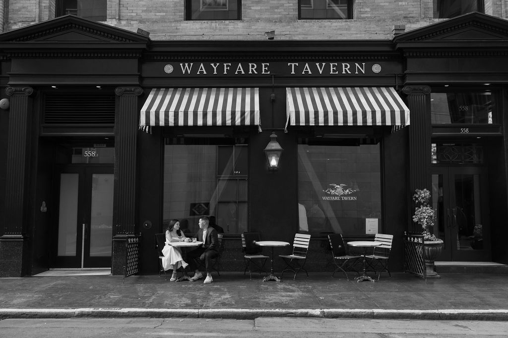 A couple posing for bar engagement photos at Wayfare Tavern