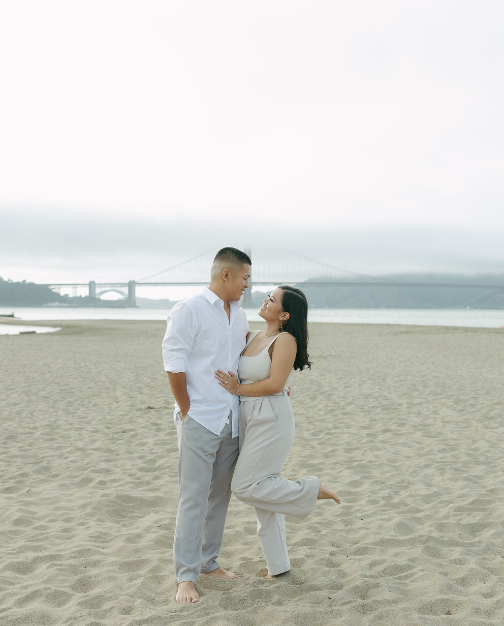 A couple taking beach engagement photos in Northern California