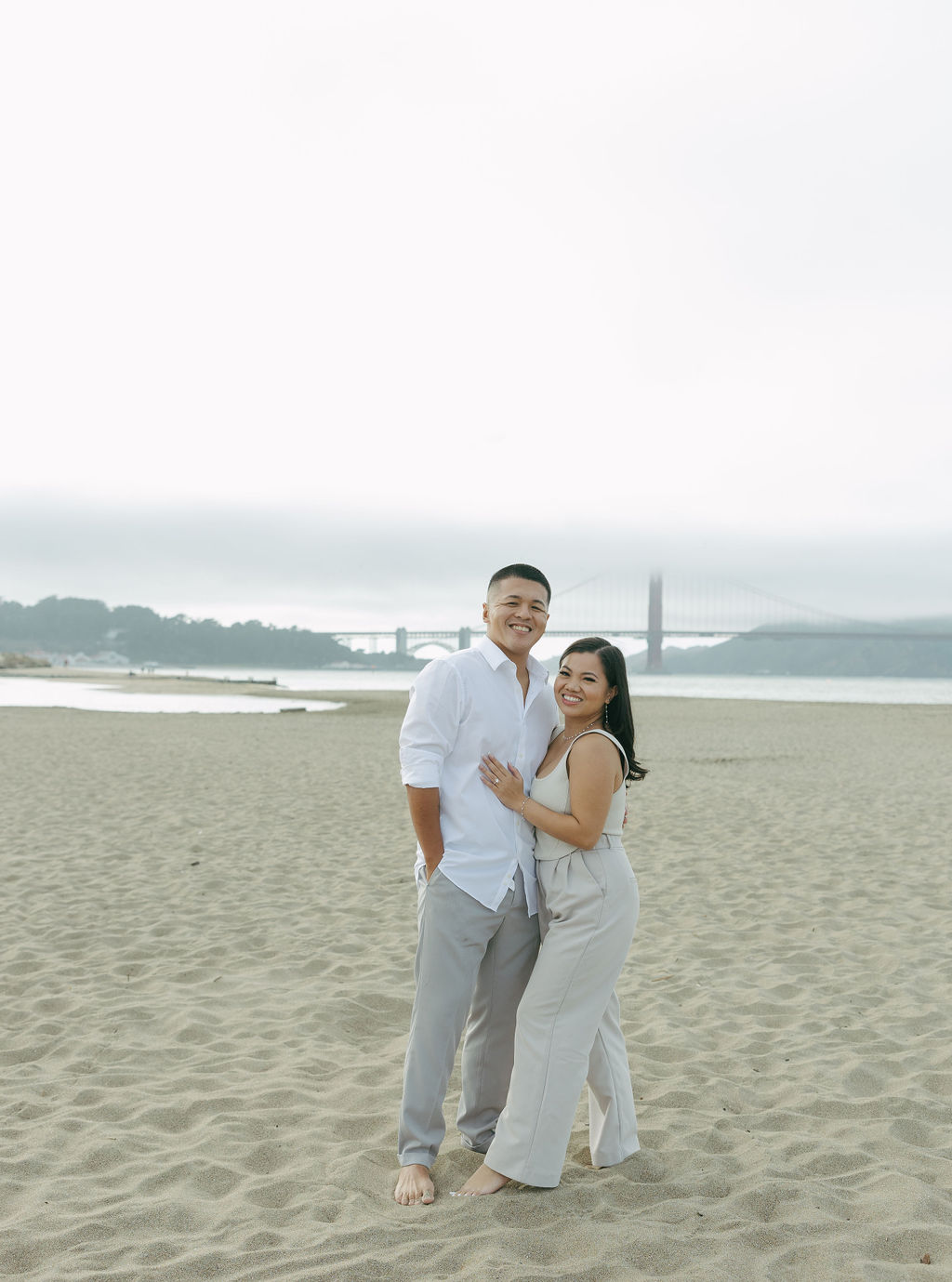 A couple taking beach engagement photos in Northern California