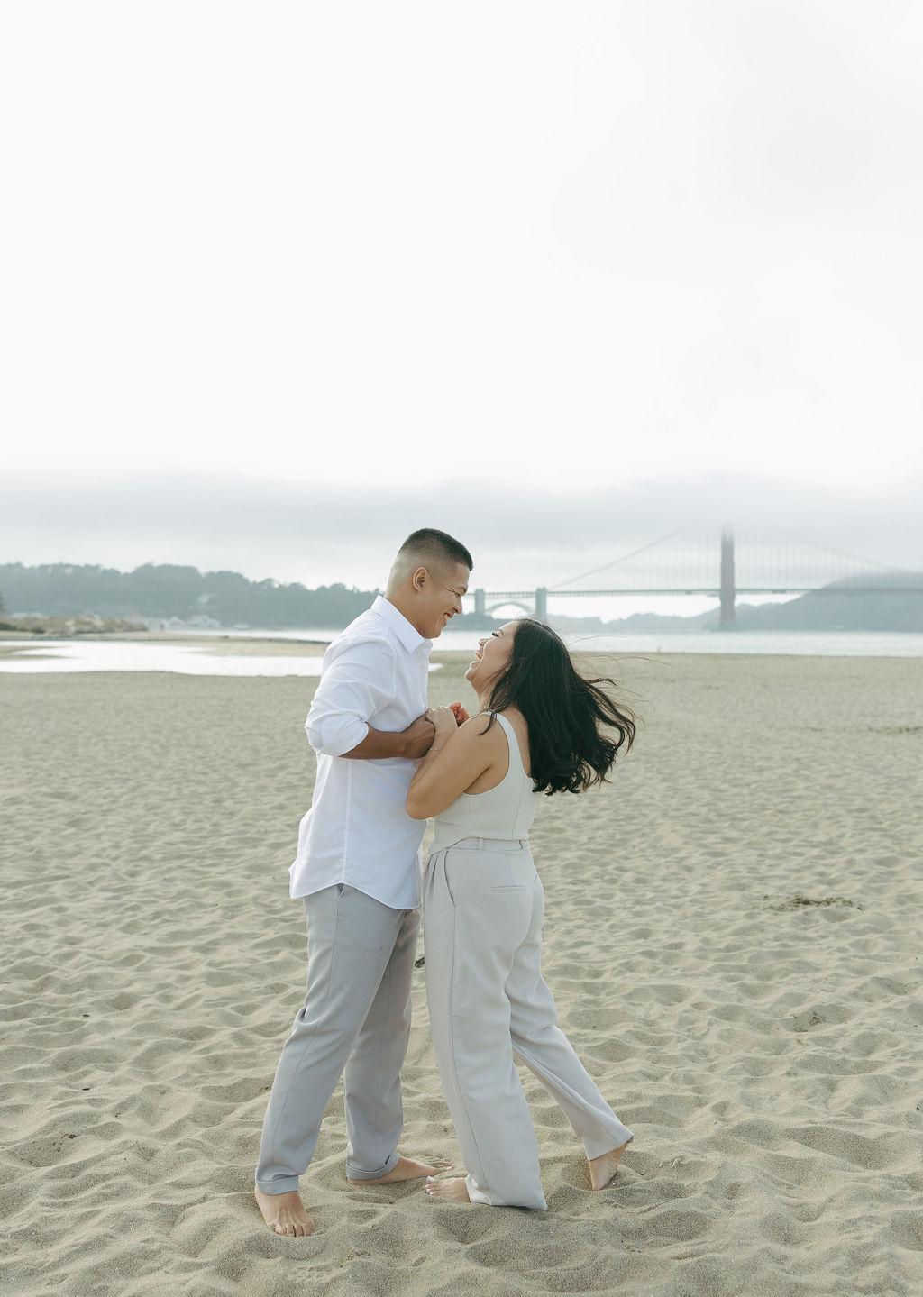 A couple spinning during beach engagement photos