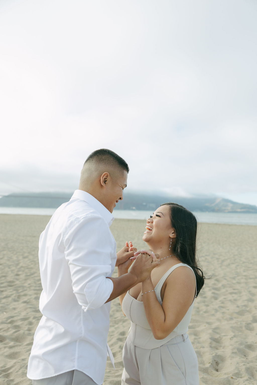 A couple smiling at each other during beach engagement photos