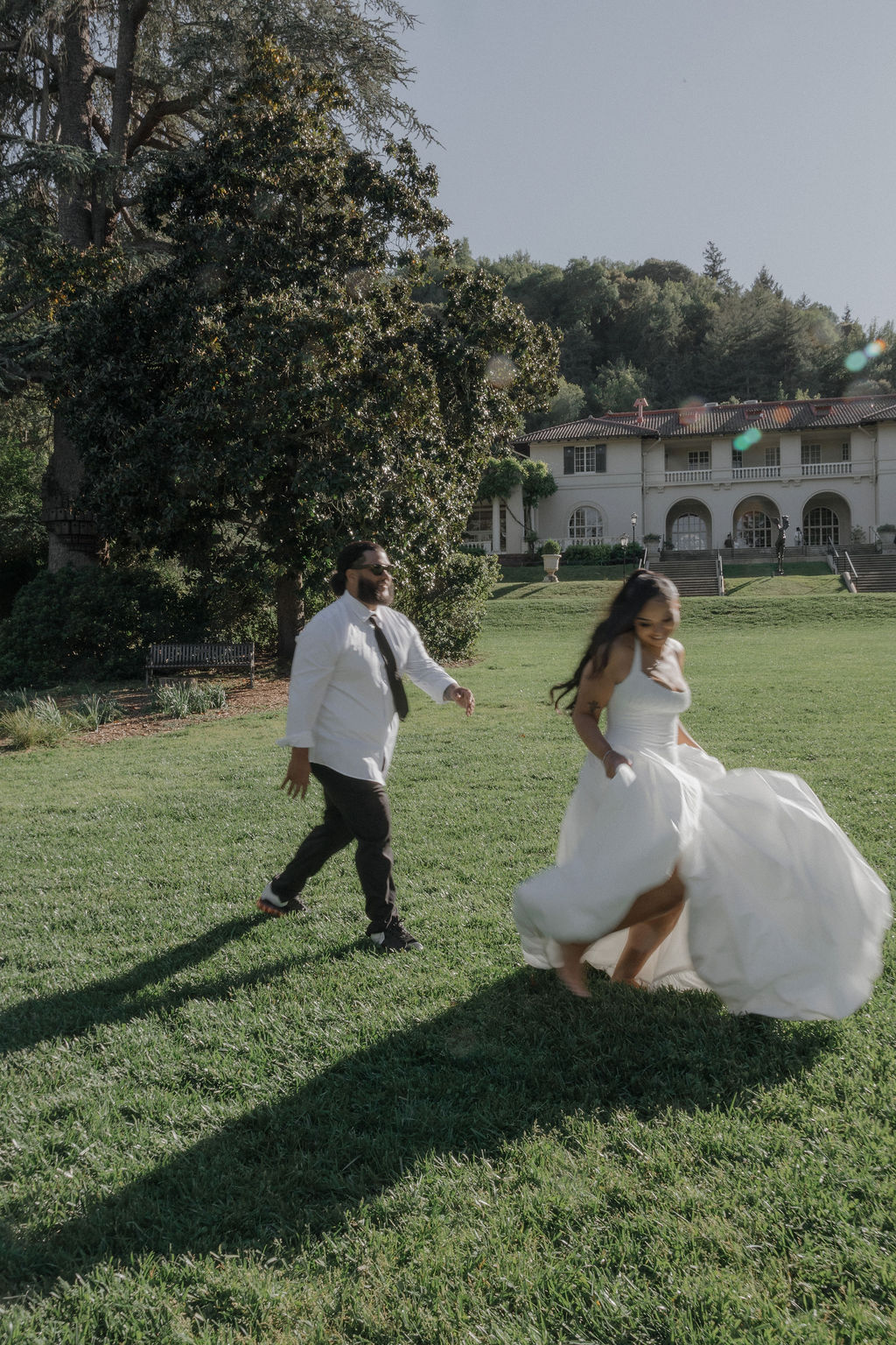 A couple running on the lawn at their Montalvo Arts Center wedding