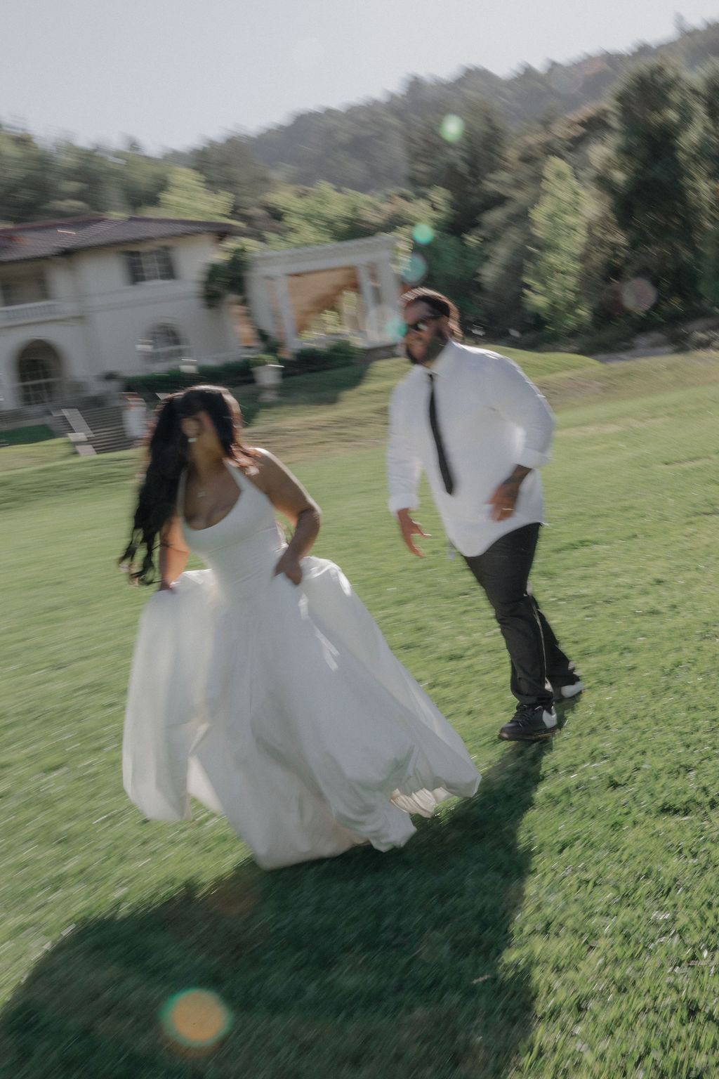 A couple running on the lawn at their Montalvo Arts Center wedding