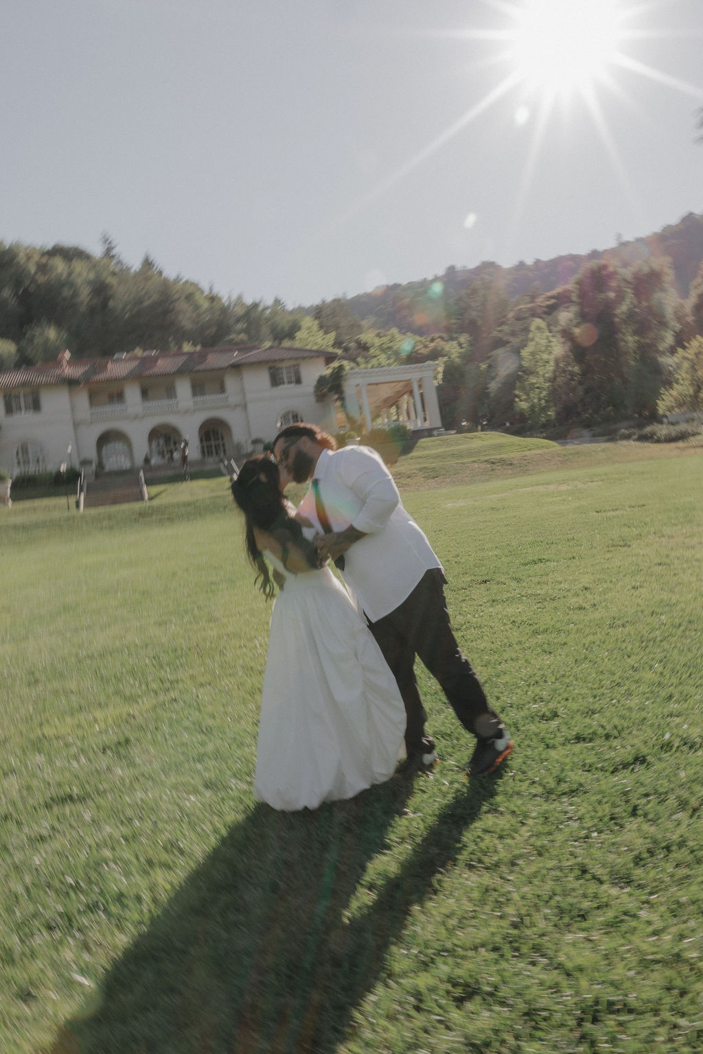 A bride and groom kissing on the front lawn at their Montalvo Arts Center wedding