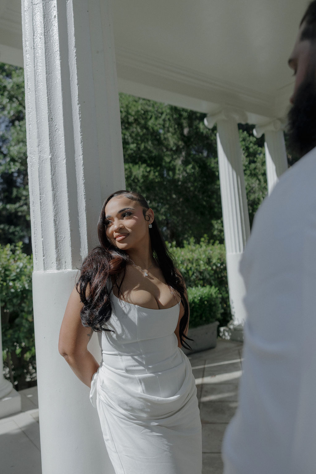 A bride posing for bridal portraits by the columns at her Montalvo Arts Center wedding