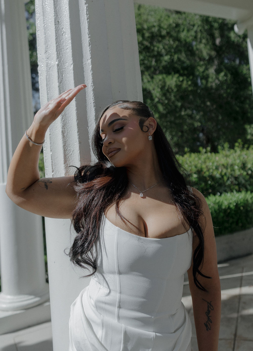 A bride posing for bridal portraits by the columns at her Montalvo Arts Center wedding