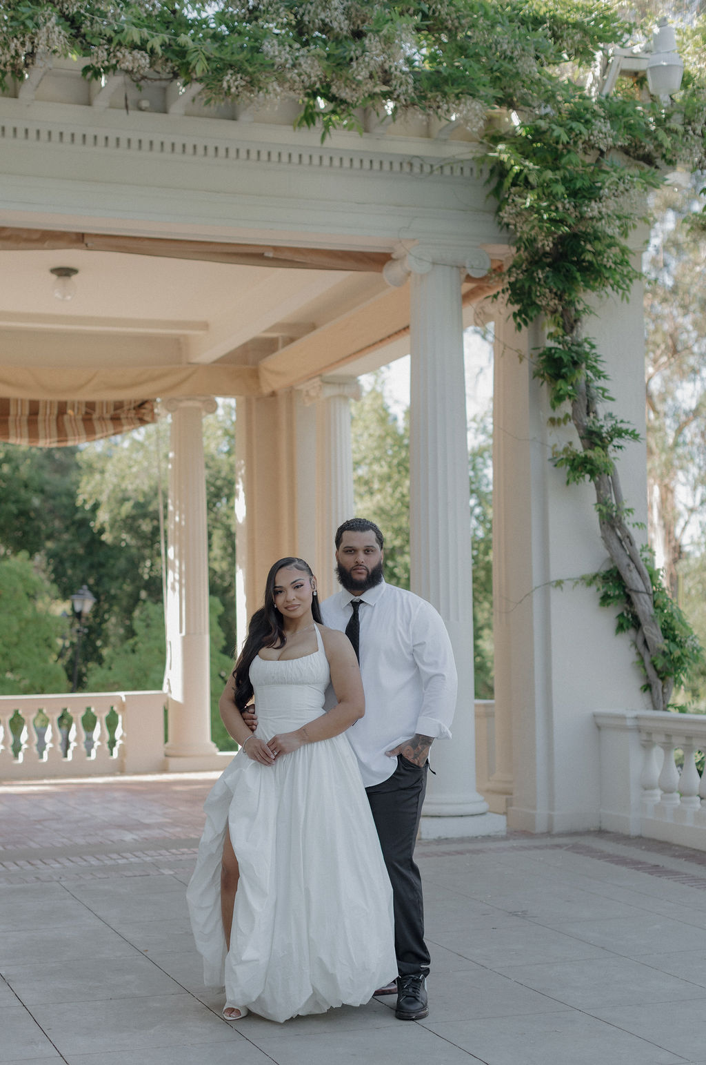 A bride and groom posing for wedding photos at Montalvo Arts Center on the courtyard