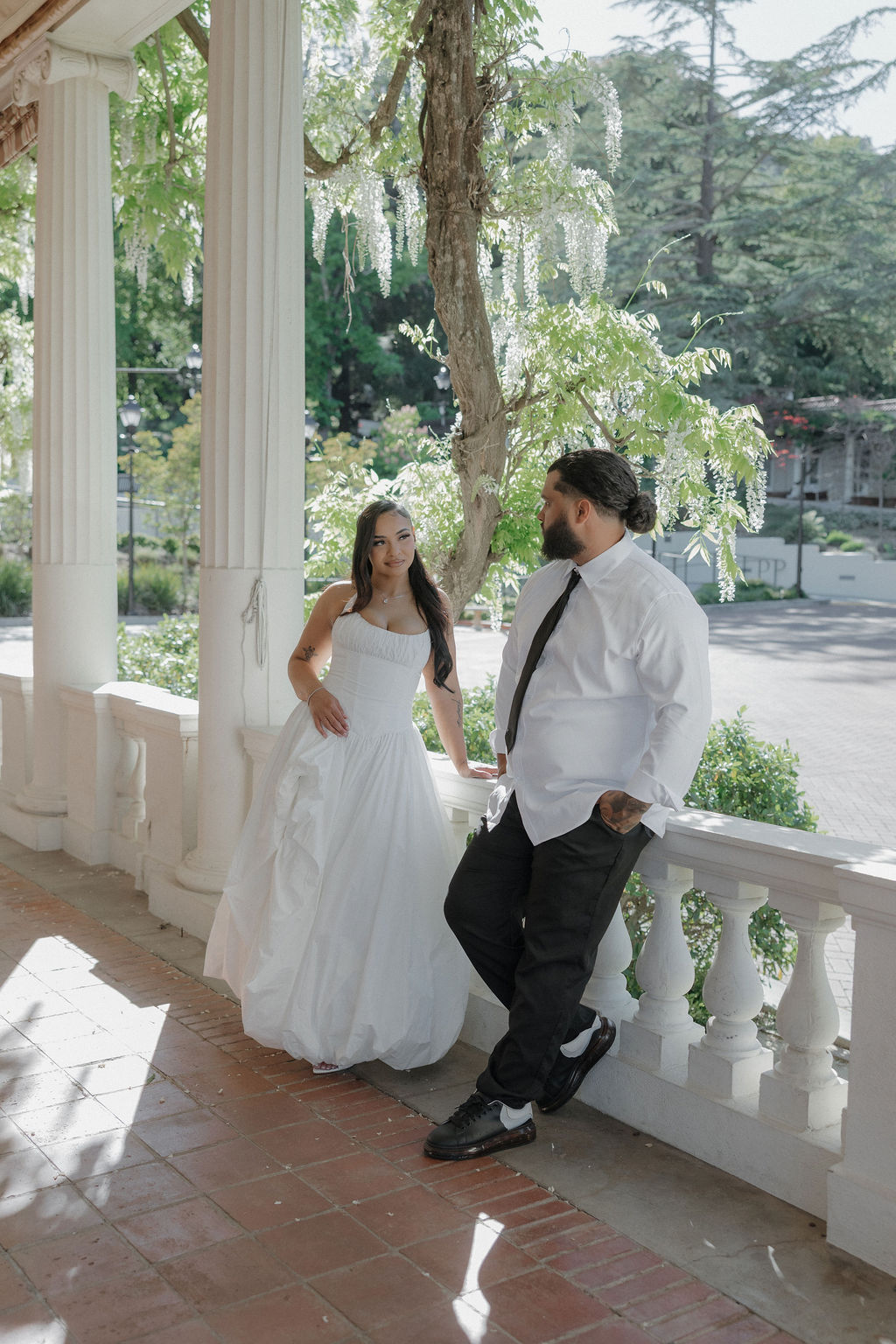 A bride and groom posing for wedding photos on a porch