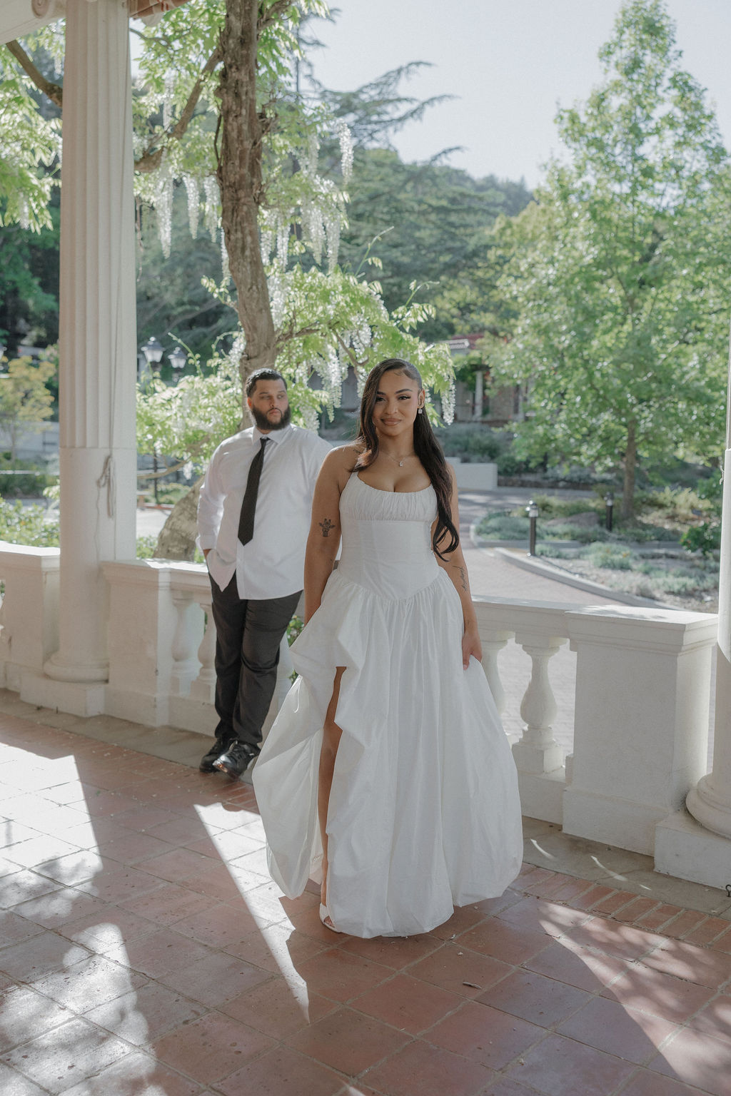 A bride and groom taking photos at their Montalvo Arts Center wedding on the porch