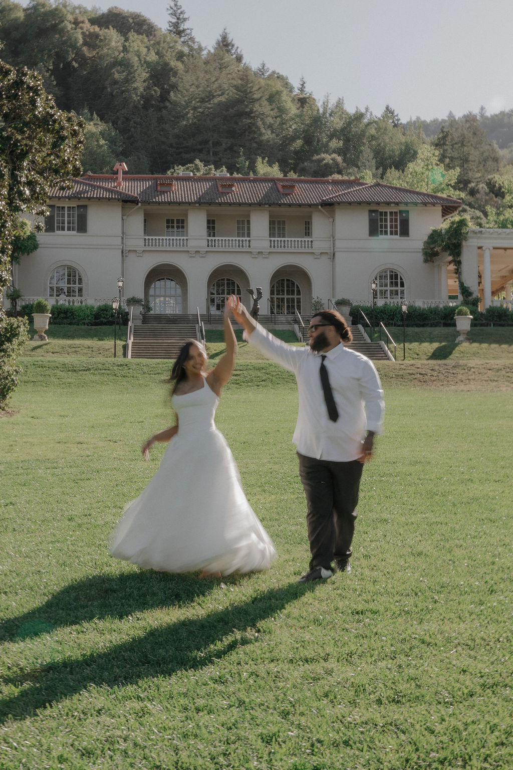 A bride and groom taking blurry engagement photos on the lawn at their Montalvo Arts Center wedding