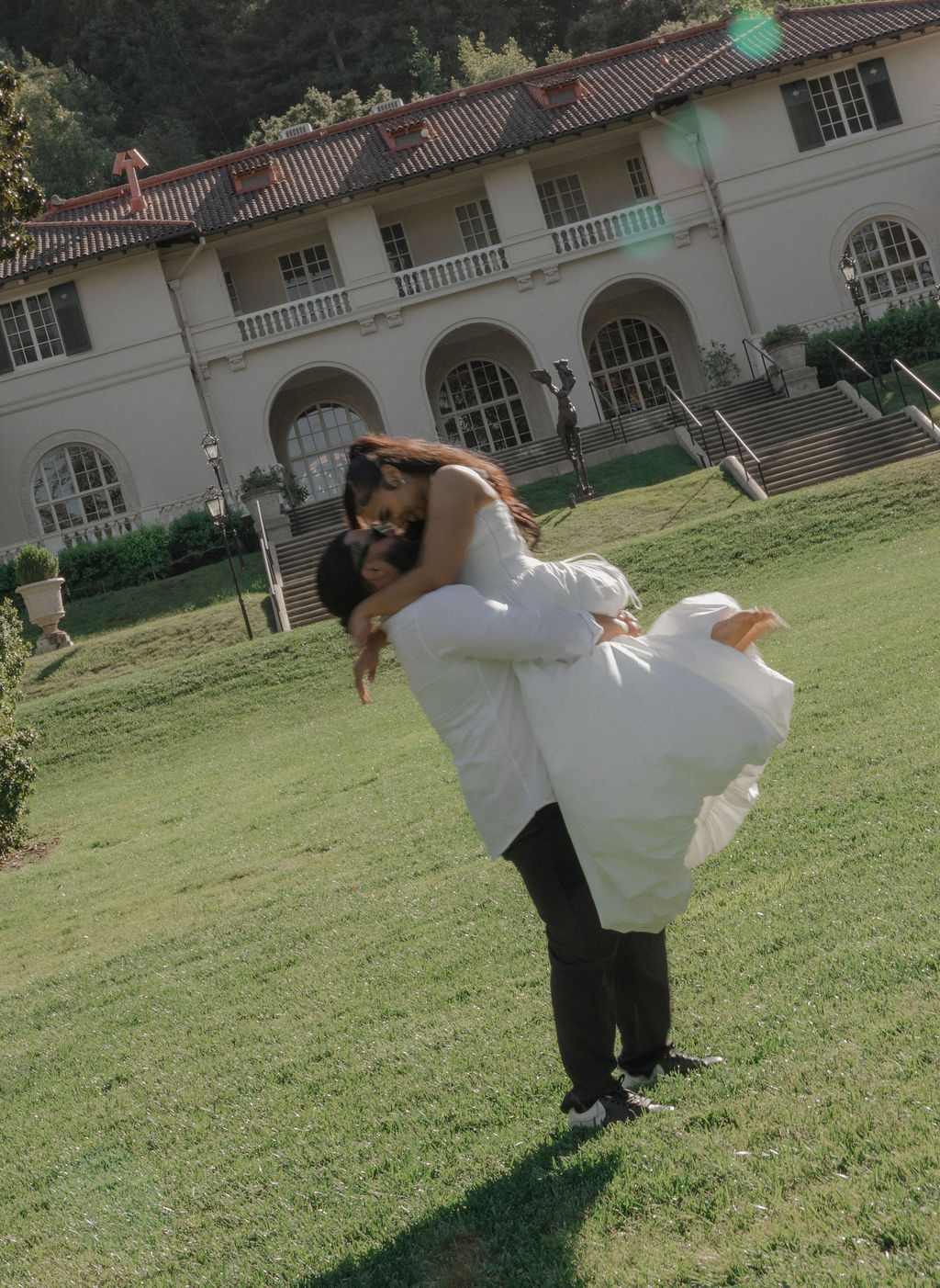 A bride and groom taking blurry engagement photos on the lawn at their Montalvo Arts Center wedding