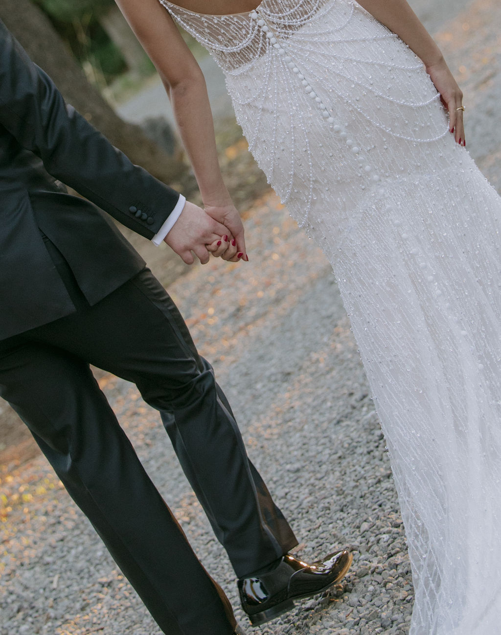 A bride and groom walking hand in hand at their park winters wedding