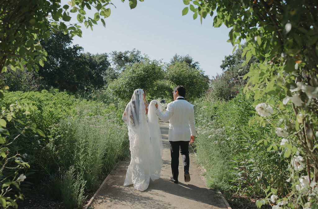 A bride and groom waling through Lamoure Vineyards