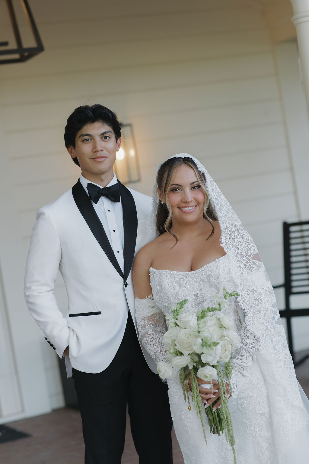 A bride and groom on the front porch at Lamoure Vineyards