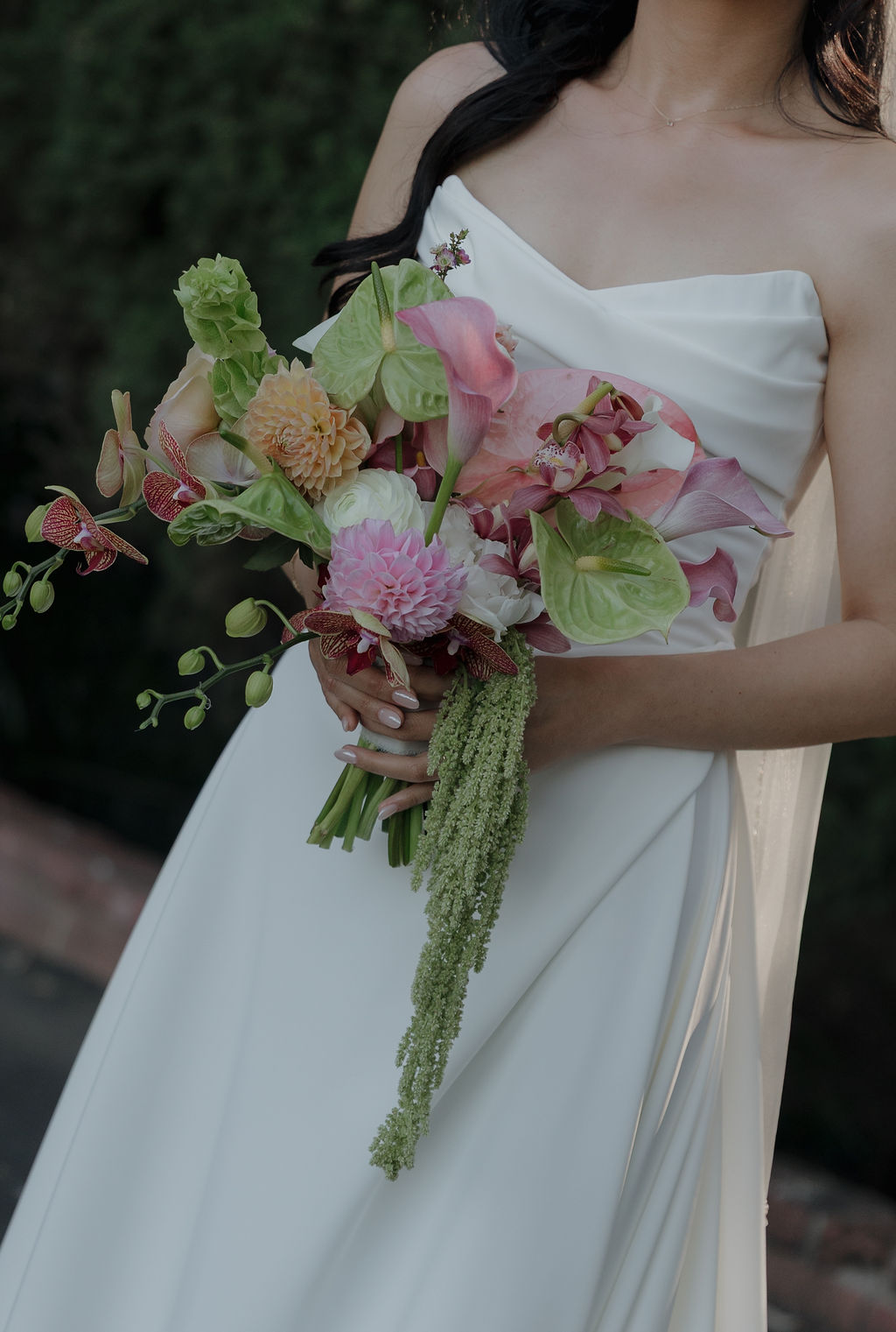 A bride holding a pink and green wedding bouquet