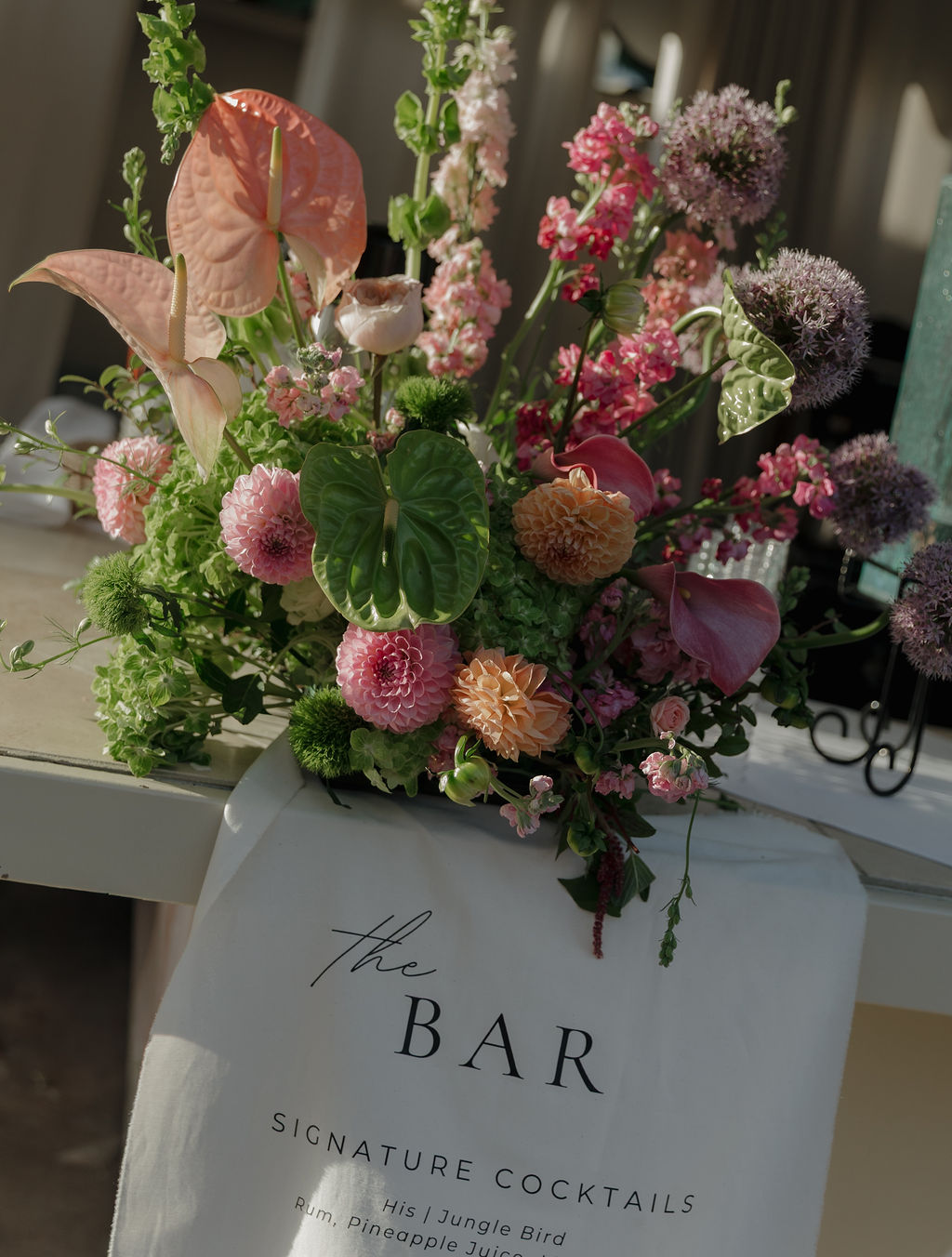 A bar wedding floral arrangement at a pink and green wedding