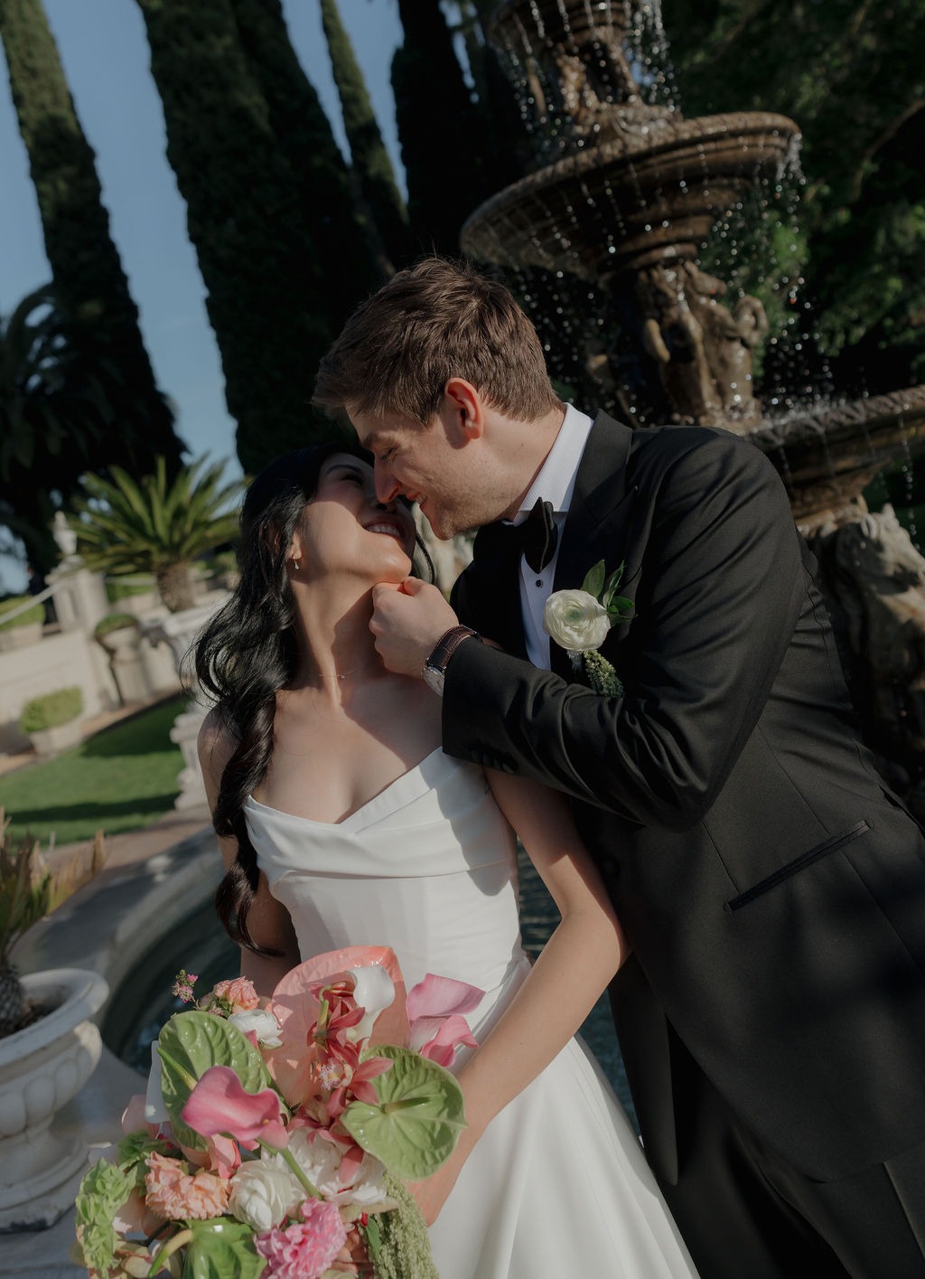 A bride and groom taking pictures for ehtie pink and green wedding