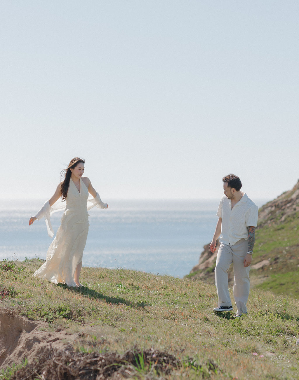 A couple taking spring engagement photos on a cliff